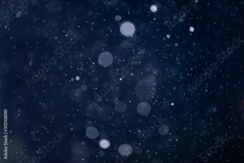 Abstract snow or rain bokeh texture overlay on blue background.