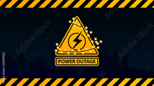 Power outage, yellow warning logo wrapped with a garland on the background of the city without electricity