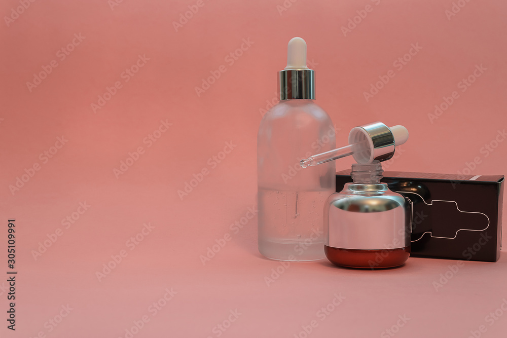 Luxury cosmetics bottle with glass pipette on pink background with space for text. Luxury cosmetics bottle with glass pipette on pink background with space for text.