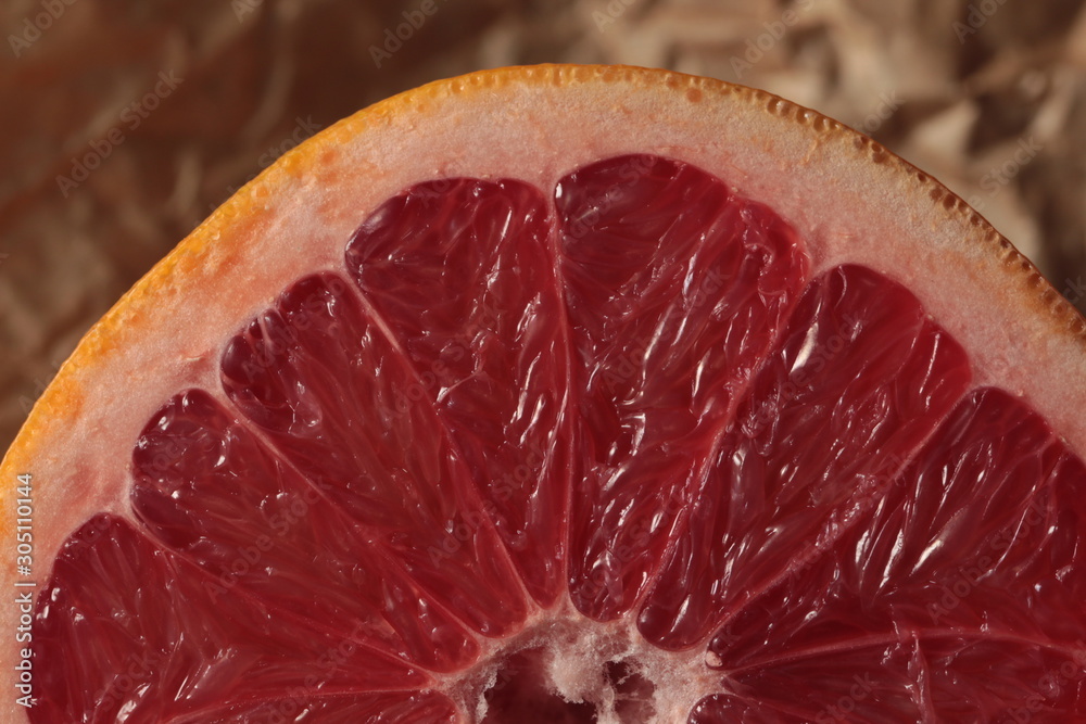 Half of grapefruit on kraft paper under studio lighting Half of grapefruit on kraft paper under studio lighting