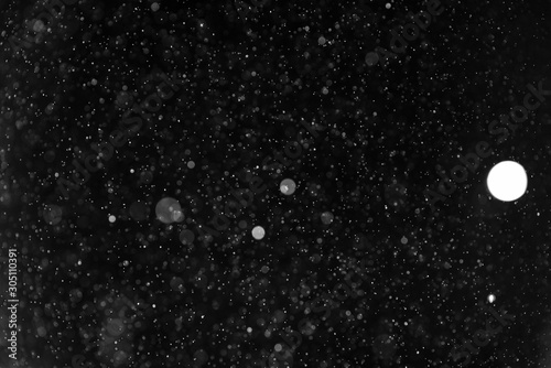Snow or rain bokeh texture on black background