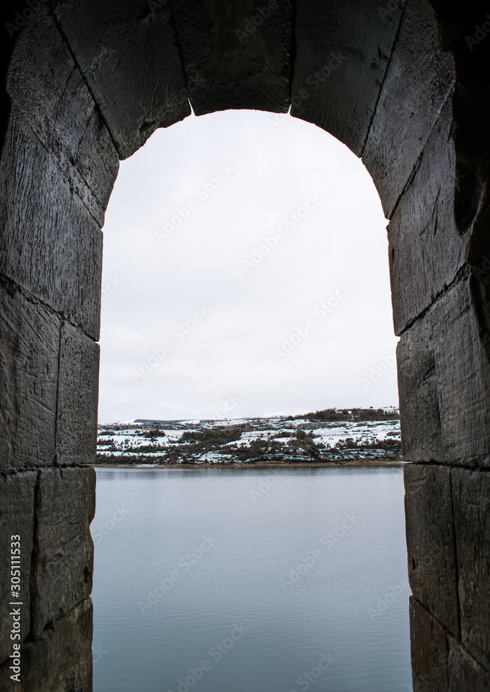 Castle window look to the snowy lake