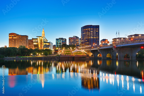 The skyline of Hartford, Connecticut at sunset. Photo shows Founders Bridge and Connecticut River. Hartford is the capital of Connecticut. 