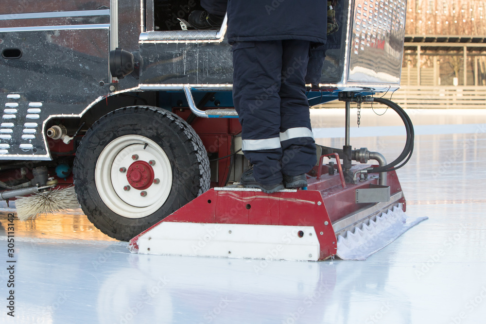 ice preparation at the rink between sessions in the evening outdoors. Polished ice ready for match. Ice MAINTENANCE MACHINE close up 