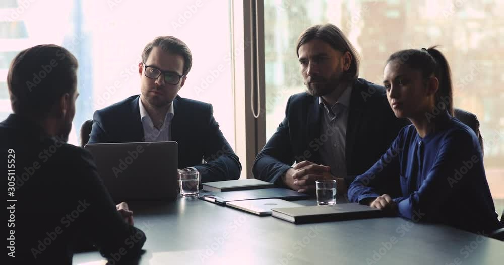 Serious attentive hr team interviewing male job applicant Serious attentive hr team interviewing male job applicant