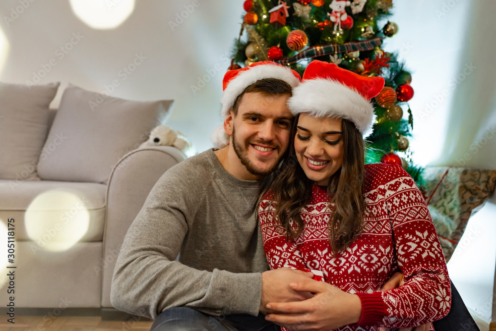 Romantic Couple Exchanging Christmas Gifts At Home. Happy couple of lovers in pullovers give each other. Christmas and new year gift at home. Young family together Romantic Couple Exchanging Christmas Gifts At Home. Happy couple of lovers in pullovers give each other. Christmas and new year gift at home. Young family together