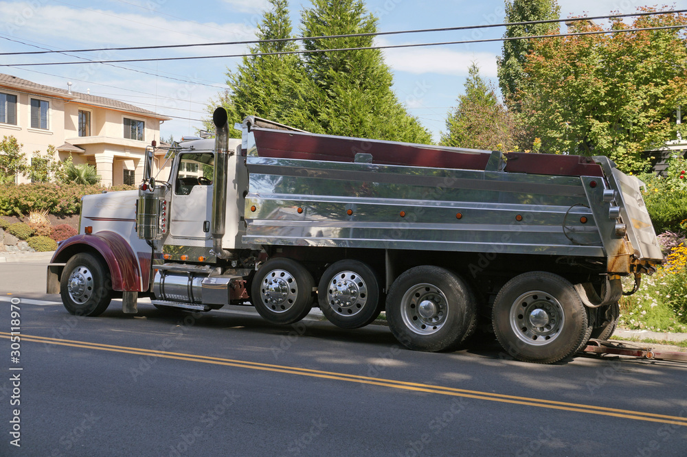 Truck (dumper) in urban traffic. A city in the USA. Roadworks.