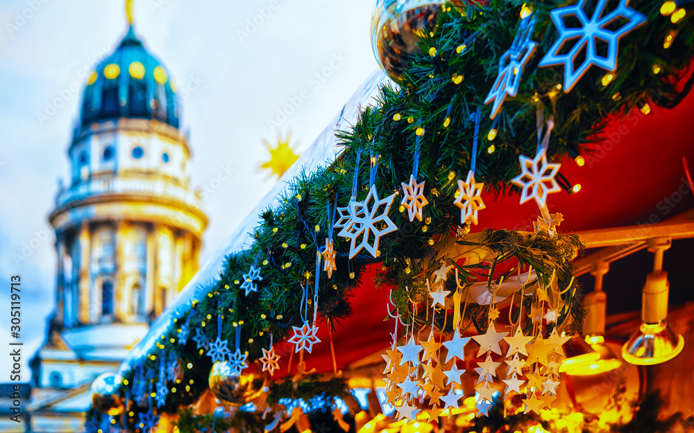 Night Christmas Market of Gendarmenmarkt in Winter Berlin, Germany. German street Xmas and holiday fair. Advent Decoration and Stalls with Crafts Items on the Bazaar.