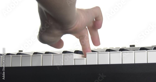 Male hand plays the piano keyboard isolated on white background. Close-up shallow depth of focus of the part. Rear view from below. Mechanics of the movement of keys are clearly visible. photo