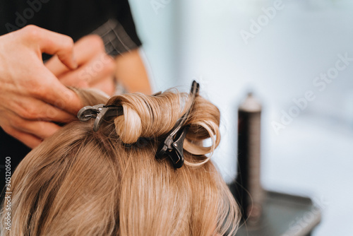 Hair stylist with blower work on woman hair