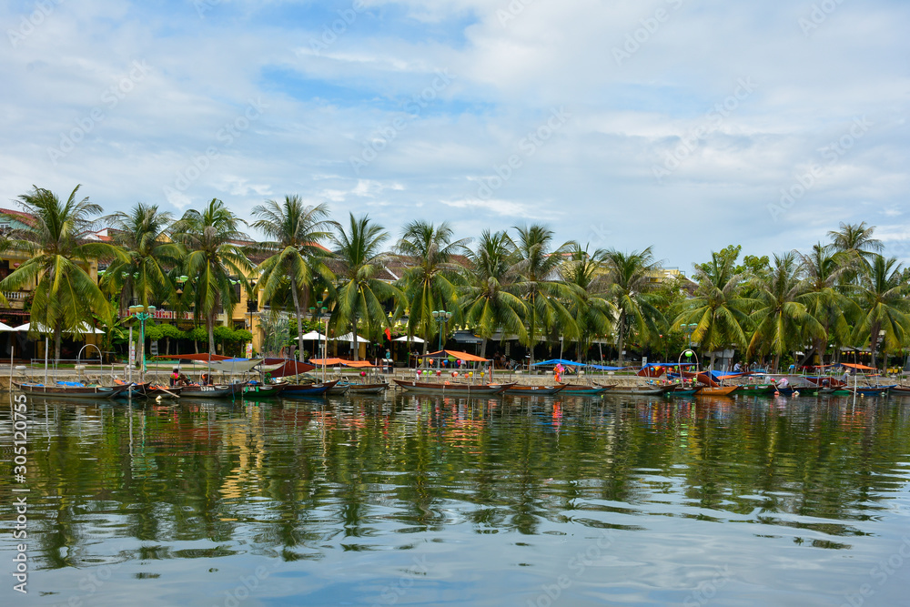 Beautiful view of boats and palm trees along Thu Bon River in Hoi An, Vietnam
