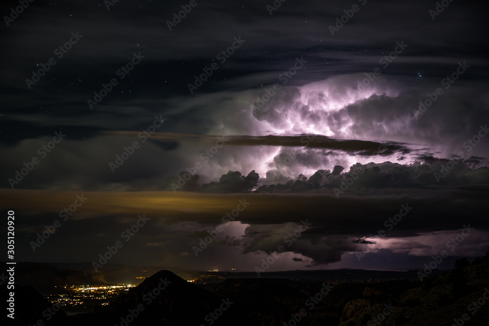 Cloud lighting in massive thunderstorm over small desert town Moab, Utah.