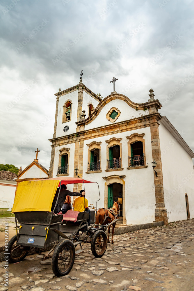 Horse and carriage on the cobblestone street in the historic church in Paraty, Rio de Janeiro, Brazil. UNESCO World Heritage Site on the Brazilian Coast