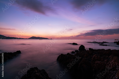 Long exposure image of Dramatic sky seascape with rock in sunset scenery background