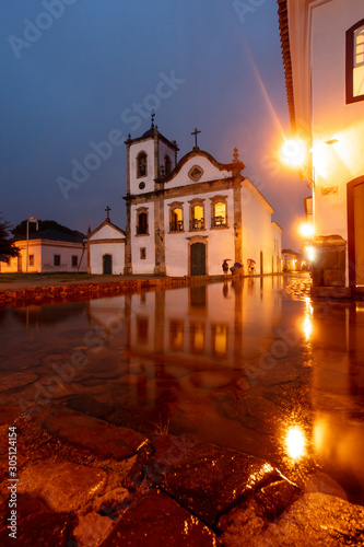 Church in flooded street at night in the historical center of Paraty, Rio de Janeiro, Brazil, World Heritage. Paraty is a preserved Portuguese colonial and Brazilian imperial city.