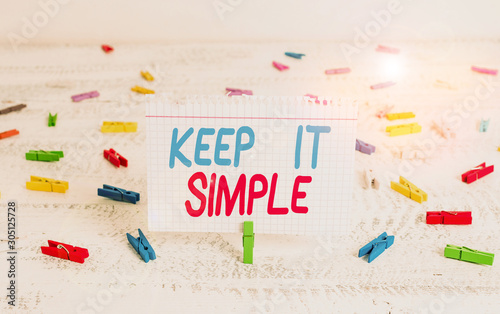Handwriting text writing Keep It Simple. Conceptual photo Remain in the simple place or position not complicated Green clothespin white wood background colored paper reminder office supply