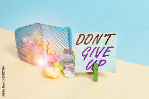 Handwriting text Don T Give Up. Conceptual photo Determined Persevering Continue to Believe in Yourself Trash bin crumpled paper clothespin empty reminder office supplies tipped photo