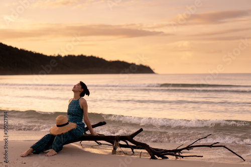 a young beauty girl at tropical beach near sea water at paradise island at sunset.