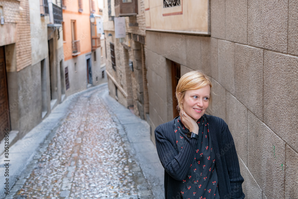 A cute woman exploring the scenic back streets of Toledo, a beautiful and historic town in Spain.