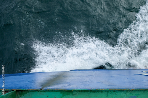 Starboard side of a ferry boat on the South China Sea being hit hard by waves in the evening.