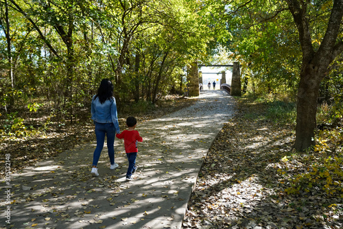 Mother and son walking along a pathway at a park in Plano, Texas