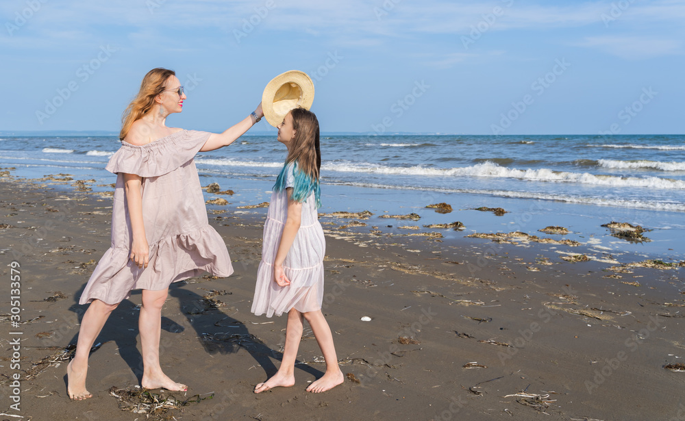 Happy mom and daughter spend time together at the seaside, family concept.