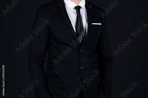 Confident businessman in black suit standing