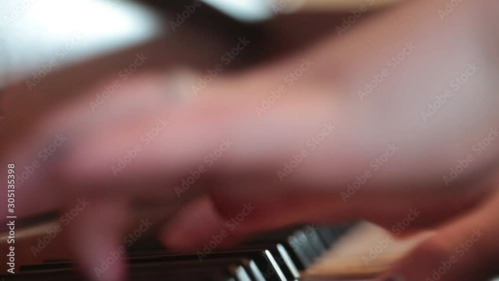  Close up of happy woman's hand playing the piano at home.