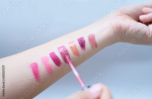 Many woman like to test swatch different color lipstics on hand. photo