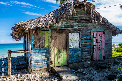 Fototapeta Naklejka Na Ścianę i Meble -  small colourful hut on the beach on the caribbean coast, with writing on the door translated, (god is faithfull)