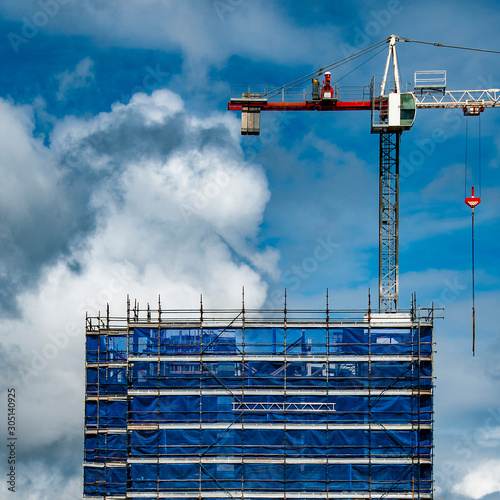 A working Construction Sky Crane on a new high rise multistory building site with blue sky background. Australia. photo