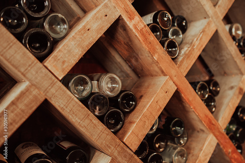 dark wooden storage cabinet for bottle with plenty of empty bottled glass