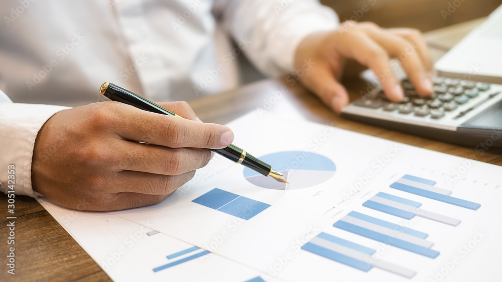 Close-up of businessman hand using calculator to calculate business data, accountancy document at home office. Close-up of businessman hand using calculator to calculate business data, accountancy document at home office.
