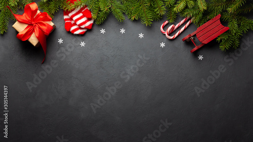 Christmas or New Year dark background. Fir tree and xmas decor. Top view with copy space.