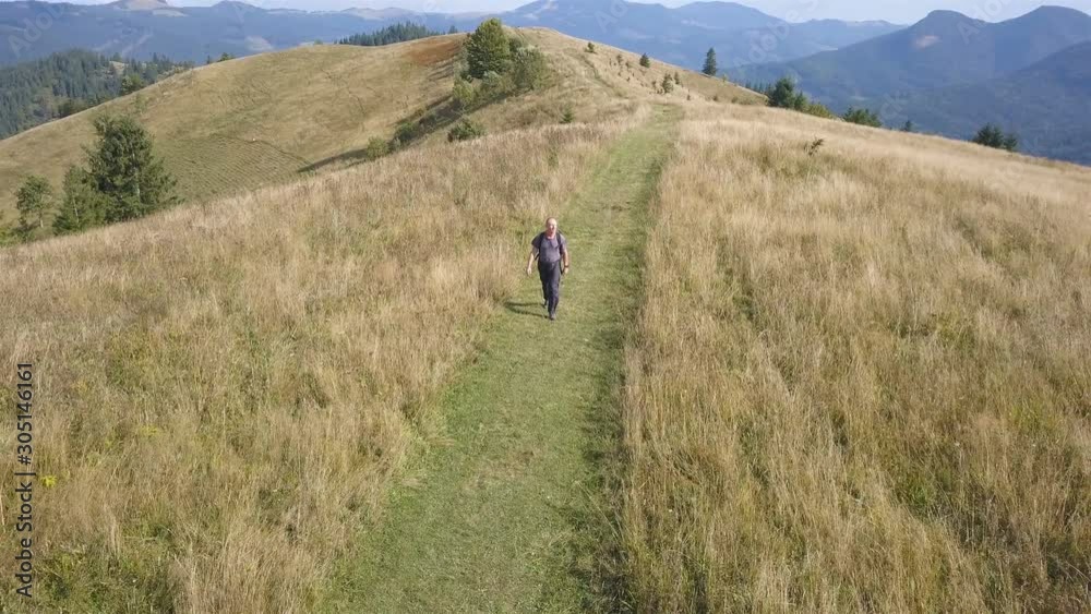 4K .Aerial travel team. Fly over adult man backpacker on ridge in autumn mountain hill. Go on camera 4K .Aerial travel team. Fly over adult man backpacker on ridge in autumn mountain hill. Go on camera