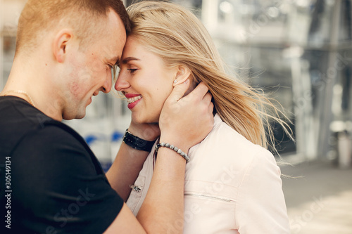 Couple in a airport. Beautiful blonde in a white jacket. Man in a black t-shirt