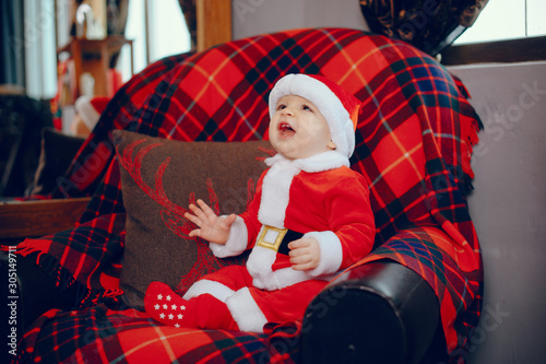 Cute little boy in a christmas costume. Child by the christmas tree