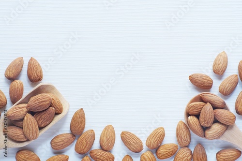 Almond nut in wood spoon on white table background