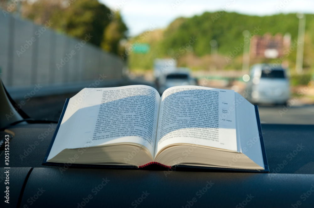 Open hebrew holy bible inside car on tomei expressway japan blurred