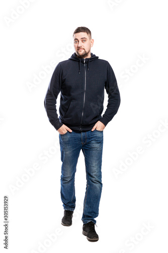 Running handsome young man in jeans. Hands in pockets. Isolated over white background. Vertical.