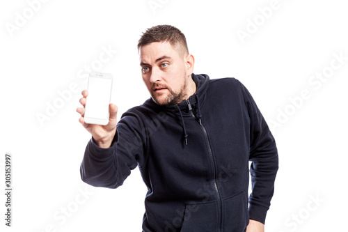 Handsome young man shows a phone with an isolated screen. Isolated over white background. © Анна Демидова