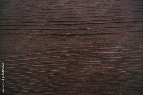 Classic brown wooden background made of dark natural wood in the style of grunge. Top view. Raw planed texture of coniferous pine varnished. The surface of the table for shooting flat lay. Copy space