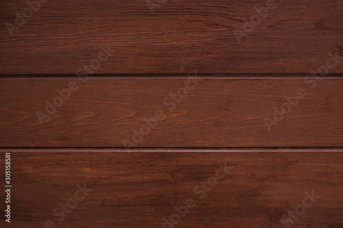 Classic brown wooden background made of dark natural wood in the style of grunge. Top view. Raw planed texture of coniferous pine varnished. The surface of the table for shooting flat lay. Copy space