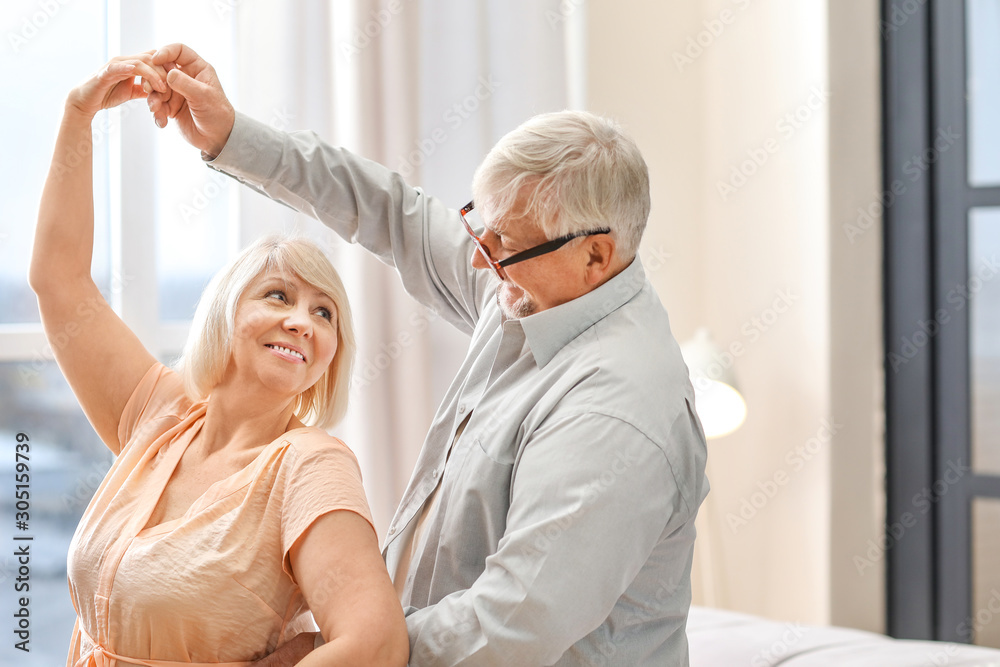 Obraz premium Happy mature couple dancing at home