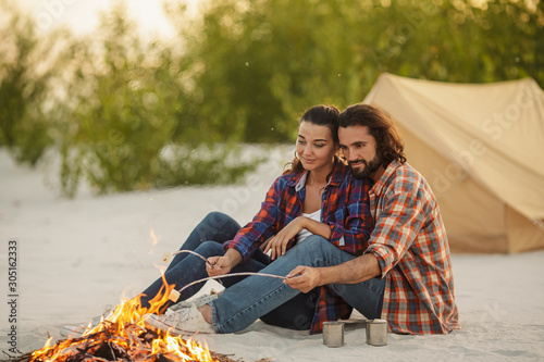 Couple Camping Near Campfire