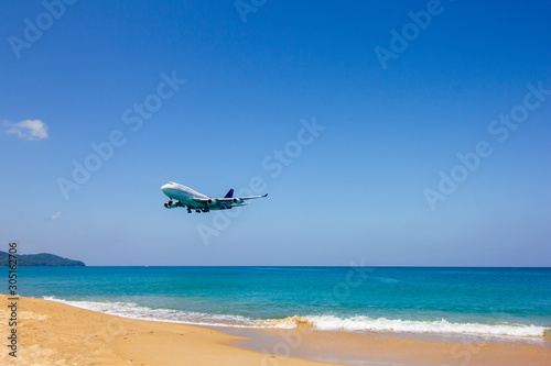 Airplane in sky with sea and beach to travel and tourism concept
