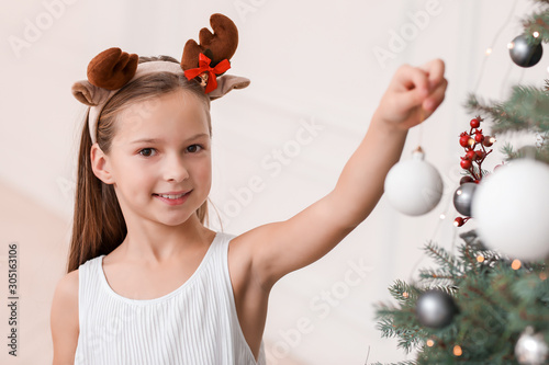 Happy little girl decoratin...