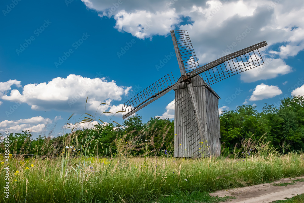 Windmill on a wheat field in the sun.