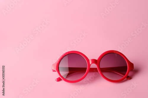 Red glasses on pink background with copy space