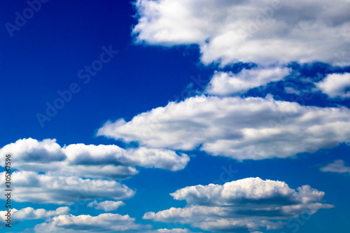 Abstract background of dense white clouds on a saturated blue sky
